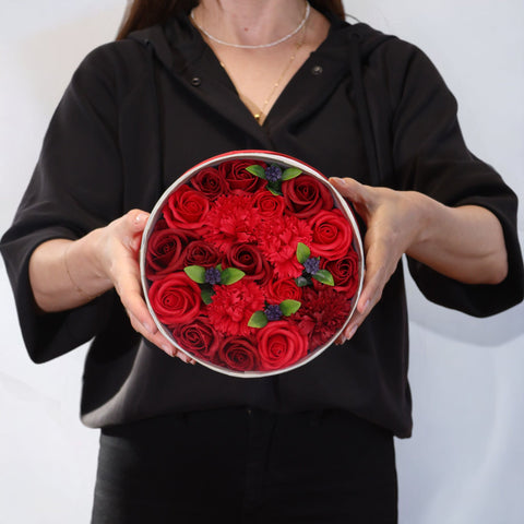 Round Box, Classic Red Roses held open in someone's hands, filled with red flower heads and green leaves