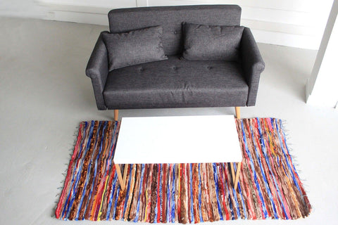 Large Velvet Rug, 105x185cm, multicoloured rug on a pale floor in front of a grey sofa and white table