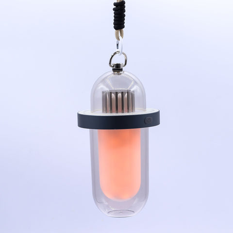 White flame effect lamp hanging from its cord, glowing orange inside against a plain background