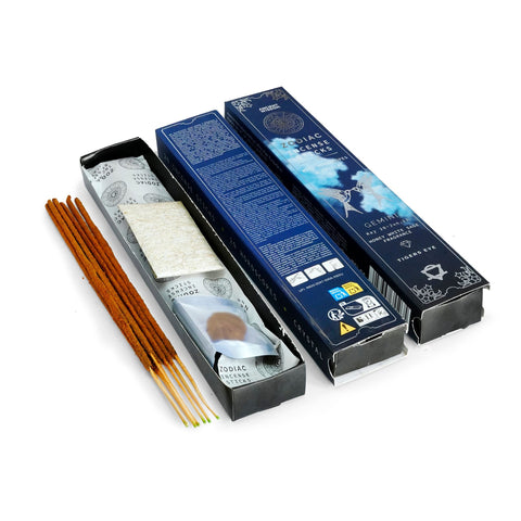 Zodiac crystal incense flatlay: sticks, a burning stick in a star holder, horoscope slips and a gemstone