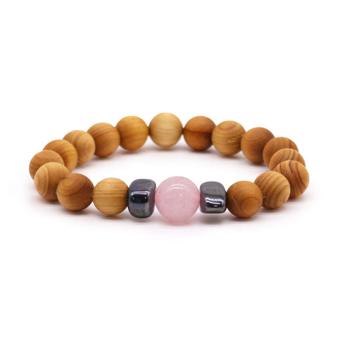 Cedarwood Heart Chakra Bangle with Rose Quartz, round tan beads and a pink bead on a white background