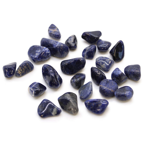 Small African Tumble Stones, Sodalite, Pure Blue, scattered dark blue stones on a white background