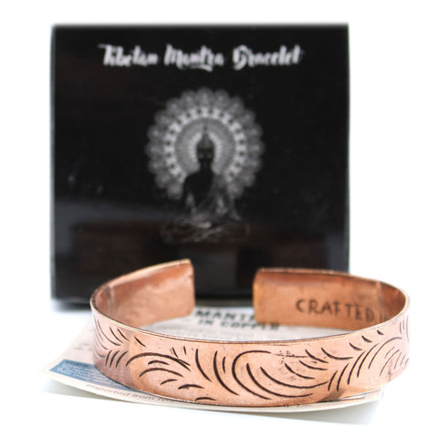 Copper Tibetan Bracelet, Wide Tribal Swirls, open cuff on a printed card in front of a black box