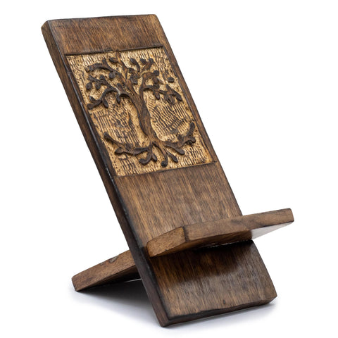 Tree of Life wooden phone stand shown empty at an angle, with its carved design and support leg visible