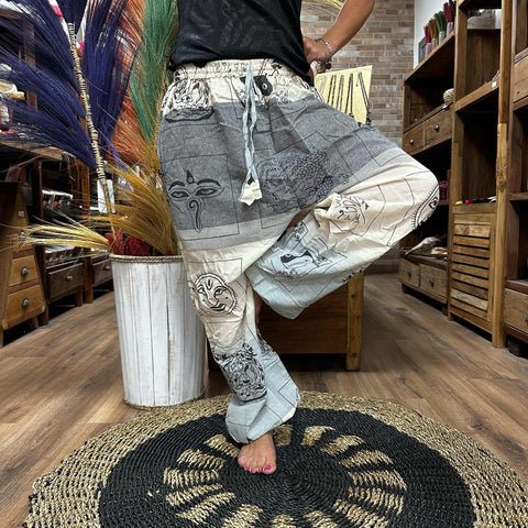 Yoga and Festival Pants, High Cross Himalayan print on grey, worn in a shop with one leg raised