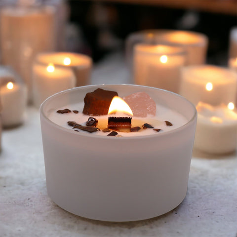 Sacral chakra crystal candle burning among a row of other lit Chakra Crystal Candles
