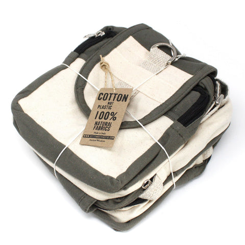 Natural Travel Bag, Charcoal folded with its front flap, zip pockets and attached cotton tag visible