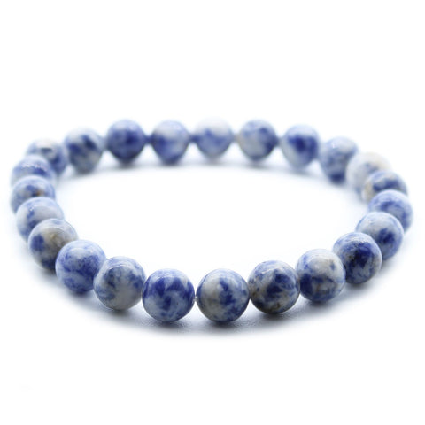 Sodalite bracelet in a close-up view, round blue and white beads against a white background