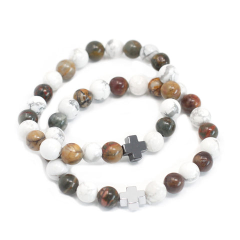 Pair of white and multicoloured gemstone bracelets arranged in overlapping circles on a white background