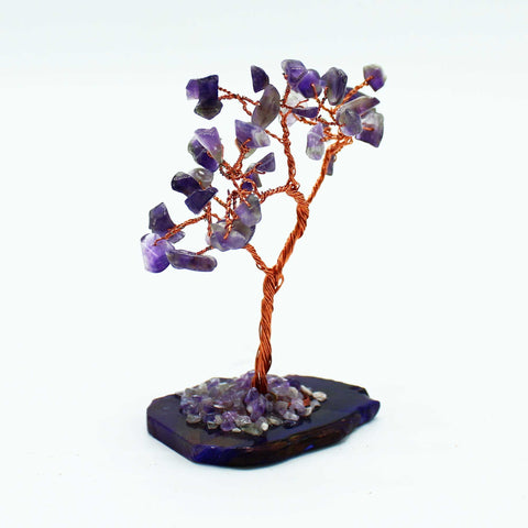 Amethyst gemstone tree standing alone against a plain white background, viewed from the front