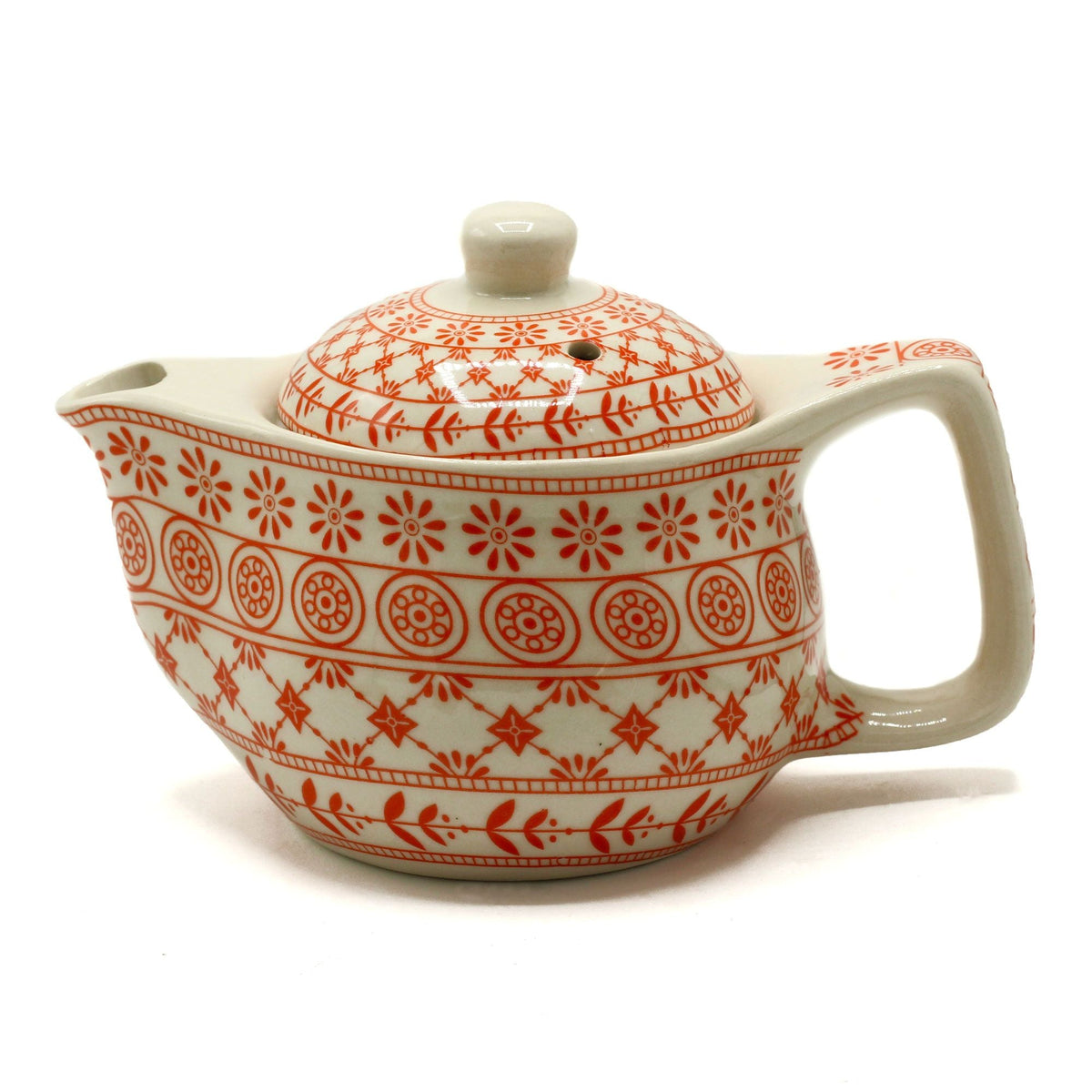 Cream teapot with orange patterned decoration and a lid on a white background.