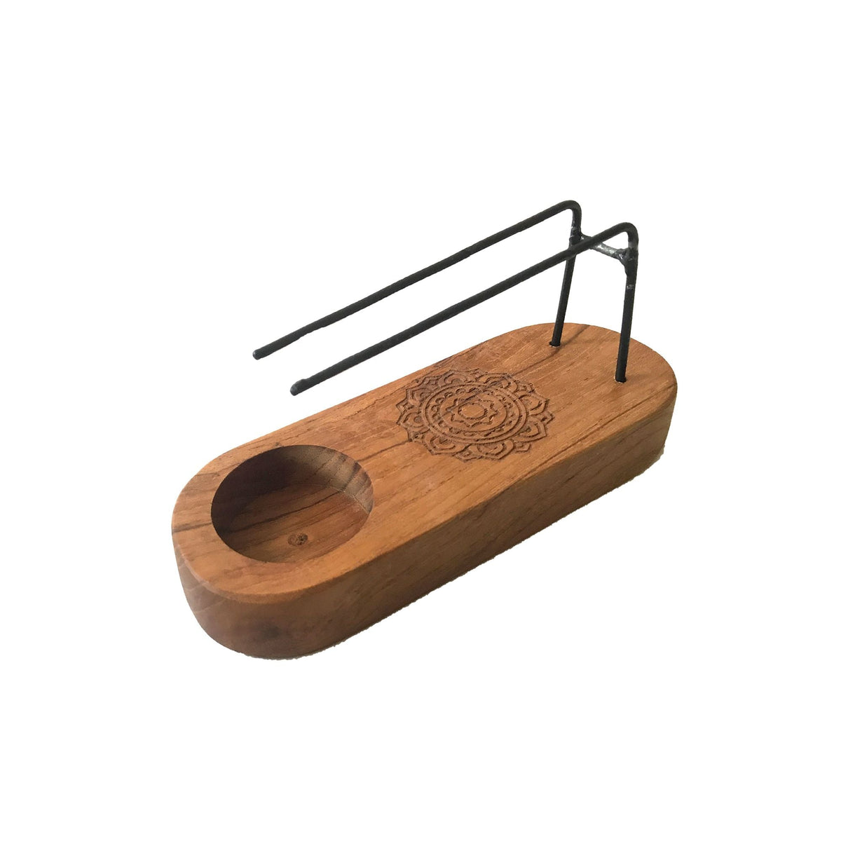 Small wooden holder with a carved mandala and two black metal rods on a white background.