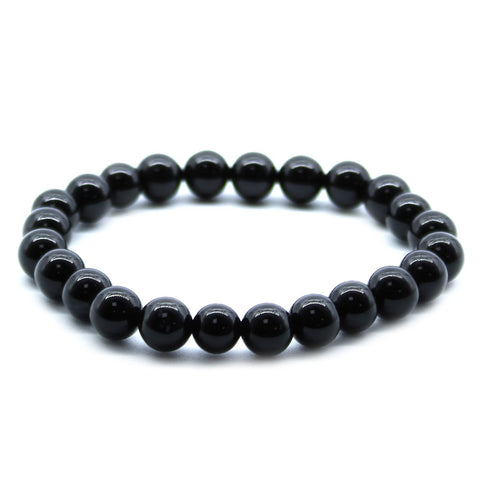 Close view of the black agate beaded bracelet arranged in a circle on a plain white background