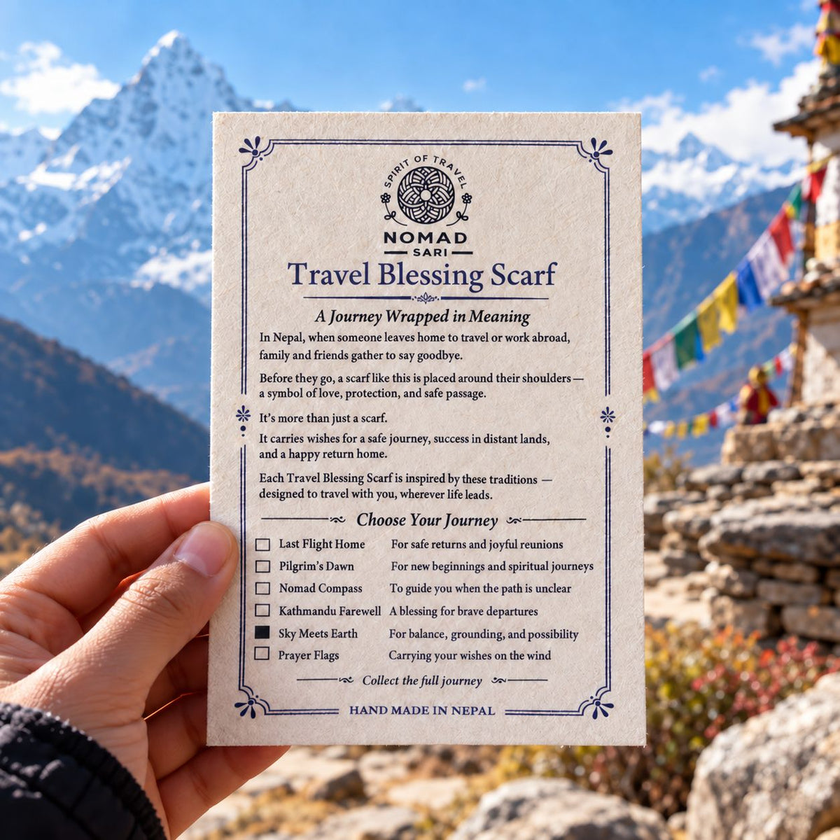 Travel Blessing Scarf packaging held against a mountain landscape