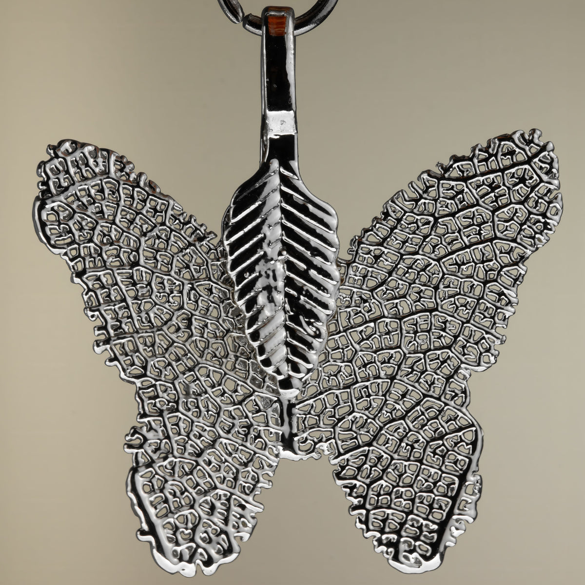 Close-up of a silver-coloured butterfly pendant