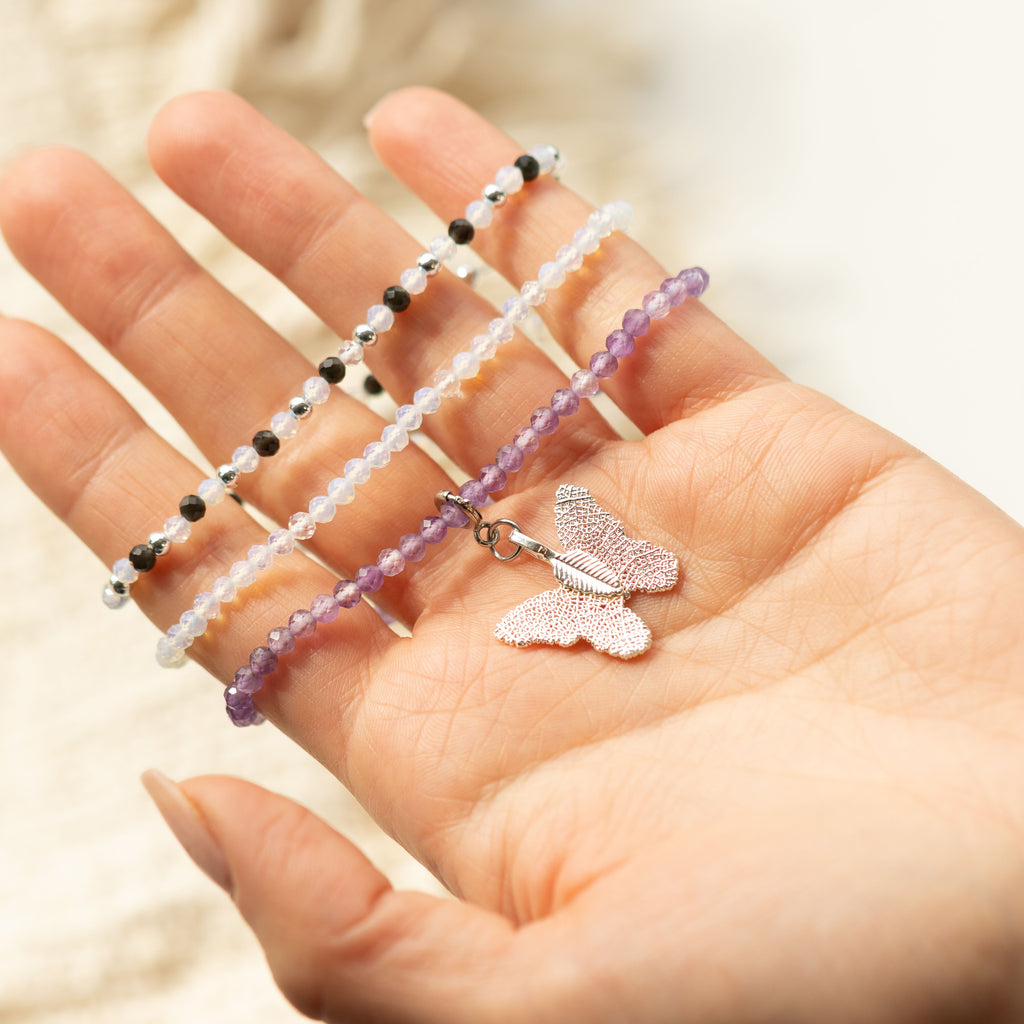 Three bracelets spread across a hand