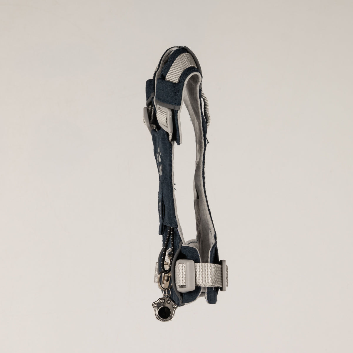 Side view of the PAW harness with its paw charm and adjustable straps