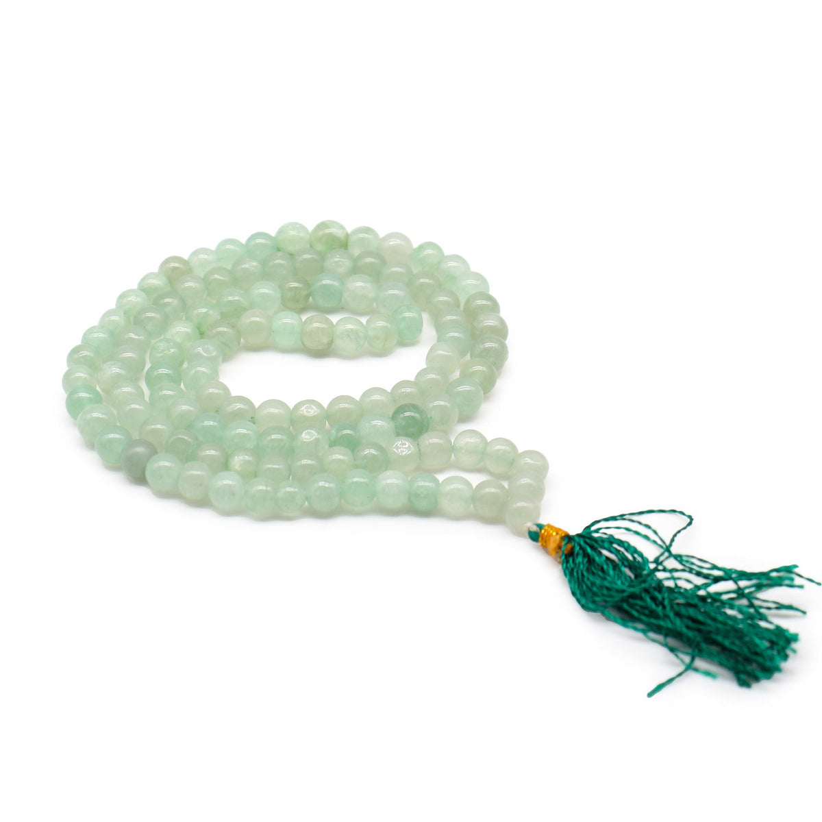 Green aventurine mala coiled on a white background, with its dark green tassel beside it