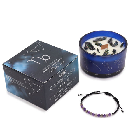 Capricorn candle and closed gift box standing together with the gemstone bracelet in front