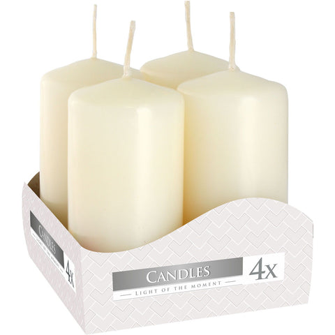 Four ivory pillar candles standing together in a printed open cardboard box