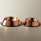 Two copper-style pet bowls shown side by side