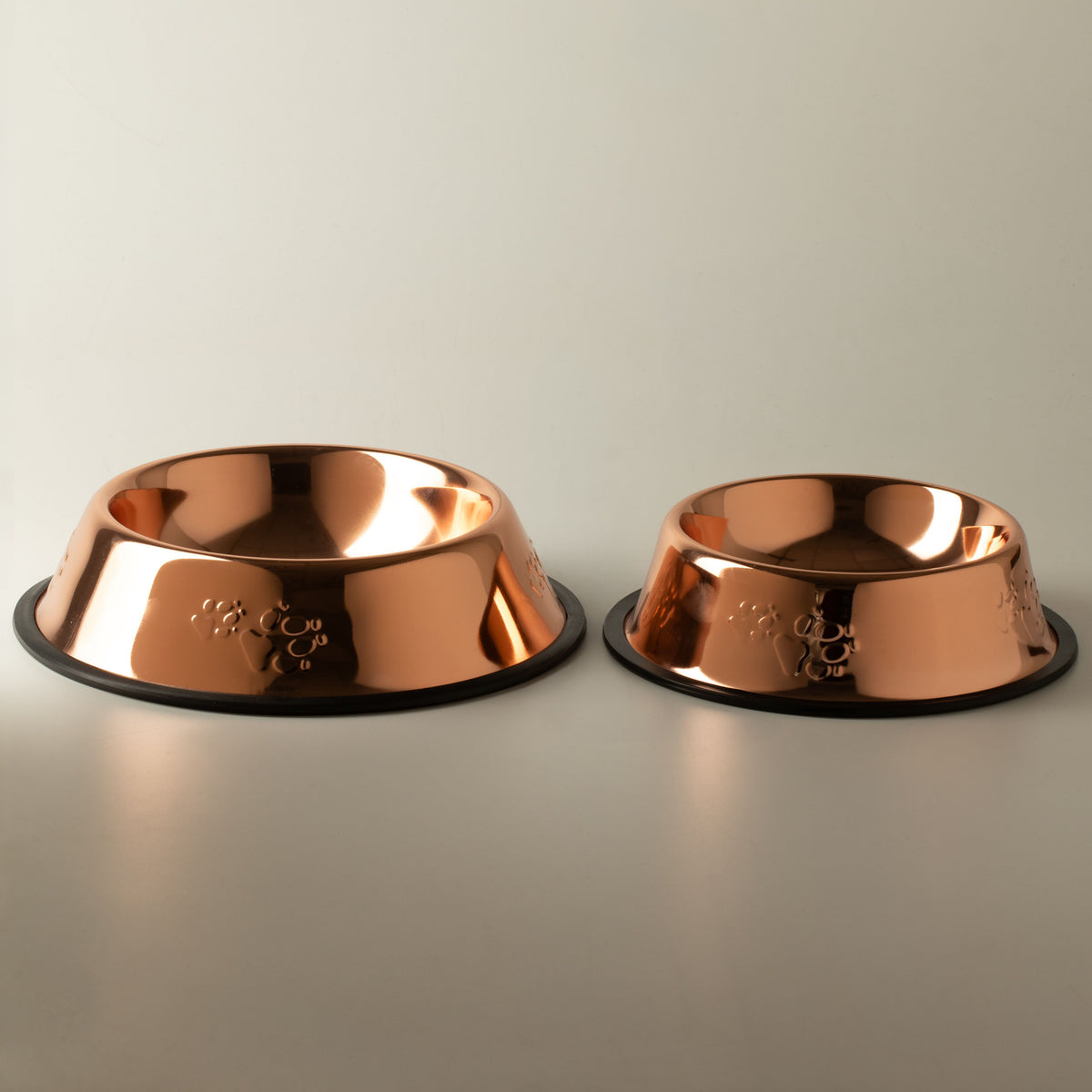 Two copper-style pet bowls shown side by side