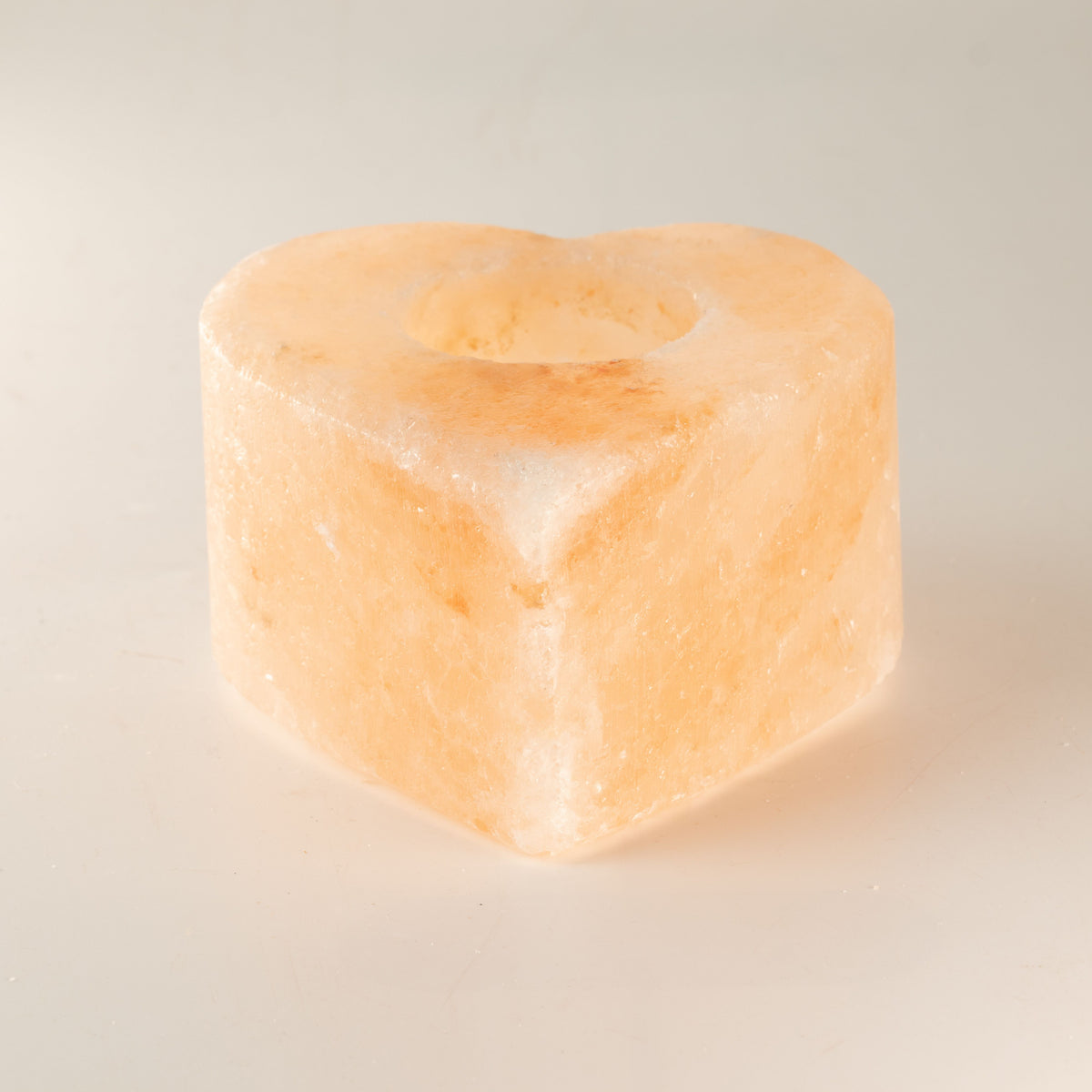 Med Heart salt candle holder, pale orange with an empty top opening, shown alone