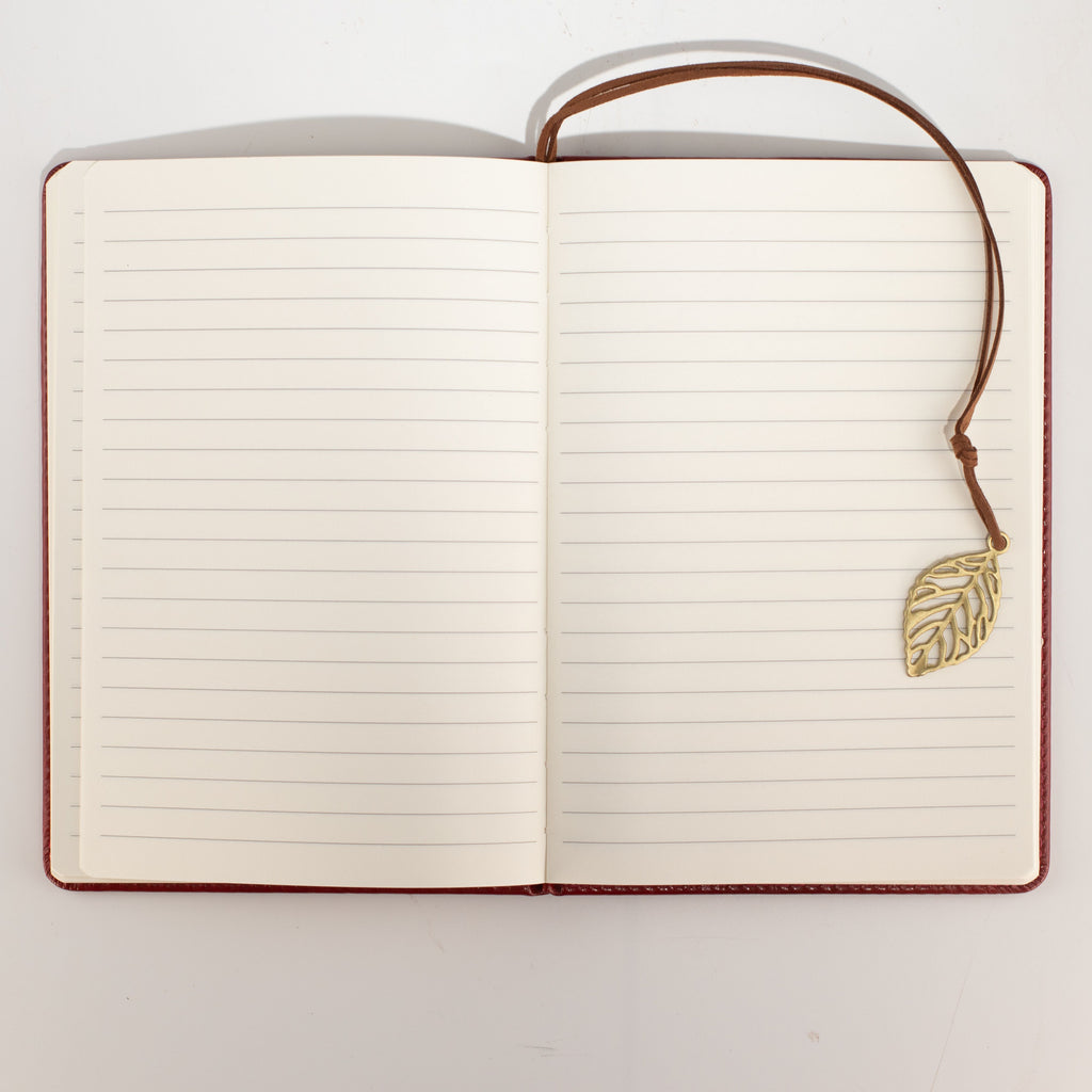 Open notebook showing lined pages and the leaf bookmark
