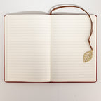 Open notebook showing lined pages and the leaf bookmark