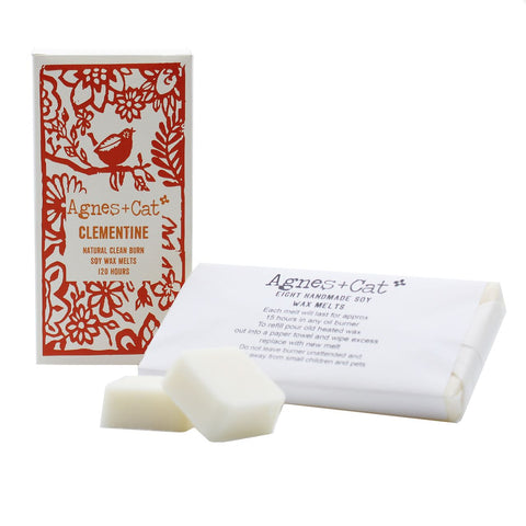 Agnes + Cat Box of 8 Wax Melts, Clementine, white melts beside the red and cream illustrated box and paper wrap