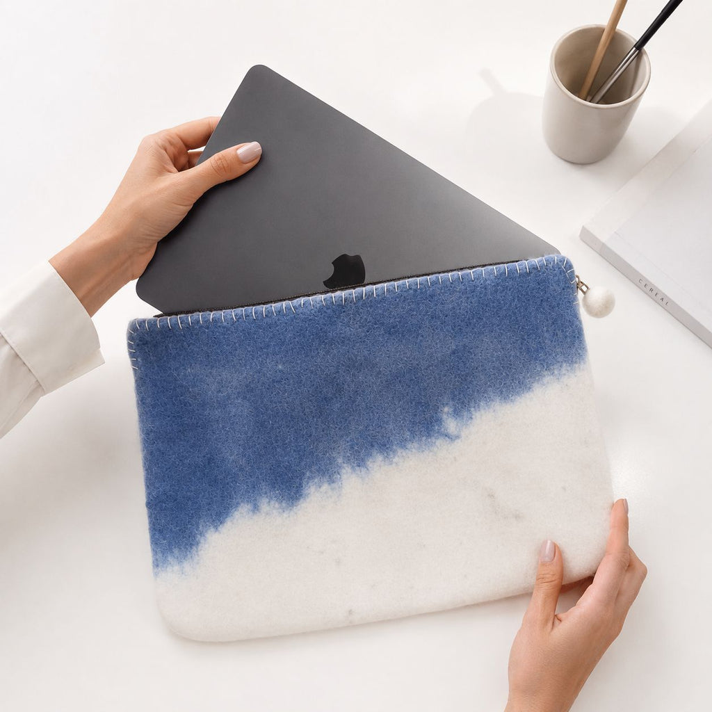 Hands holding the Blue Horizon pouch with a laptop partly inserted