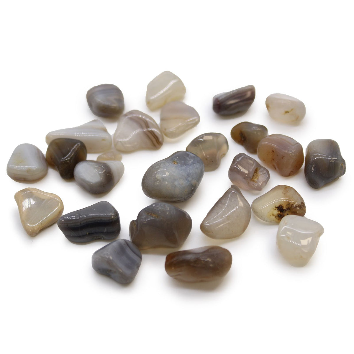 Small African Tumble Stones, Grey Agate, Botswana, assorted grey, brown and cream polished stones scattered on white