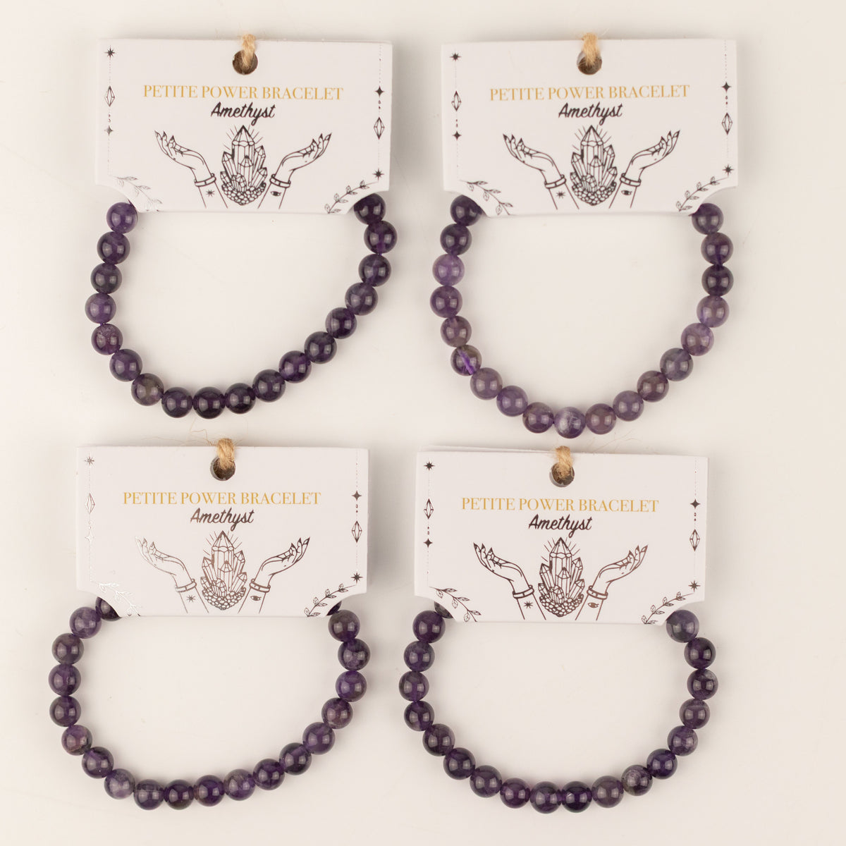 Four amethyst bracelets displayed on illustrated cards