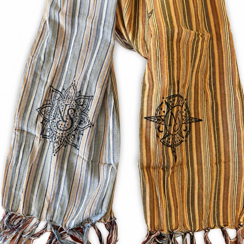 Close view of the scarf's black printed symbols and fringed ends