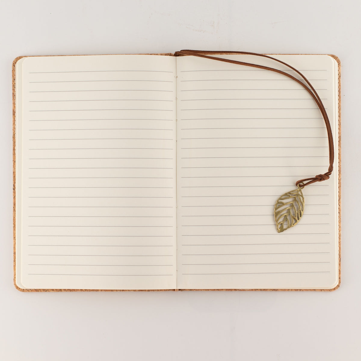 Open notebook showing lined pages and its leaf bookmark