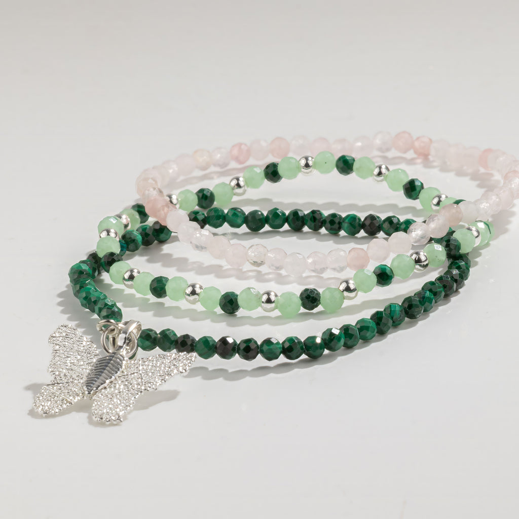Three pink and green bracelets arranged in a stack