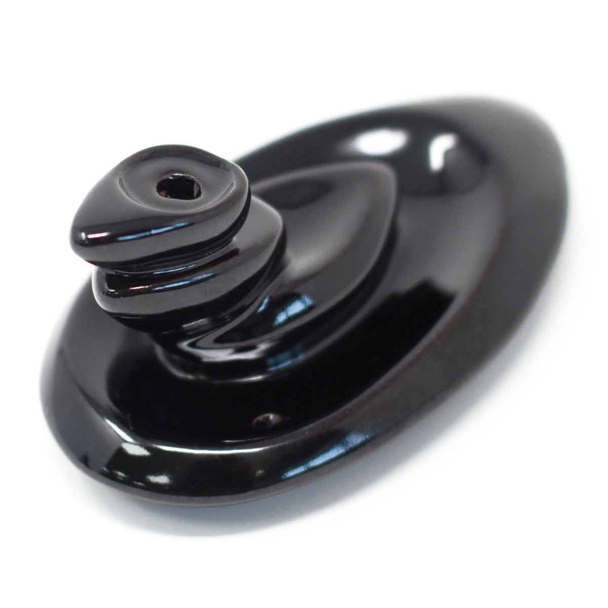 Back Flow Incense Burner, Small Pebbles, glossy black burner shown close up from above on white