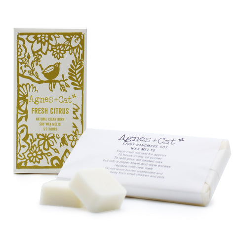 Agnes + Cat Box of 8 Wax Melts, Fresh Citrus in a gold and white illustrated box beside wrapped and loose white melts