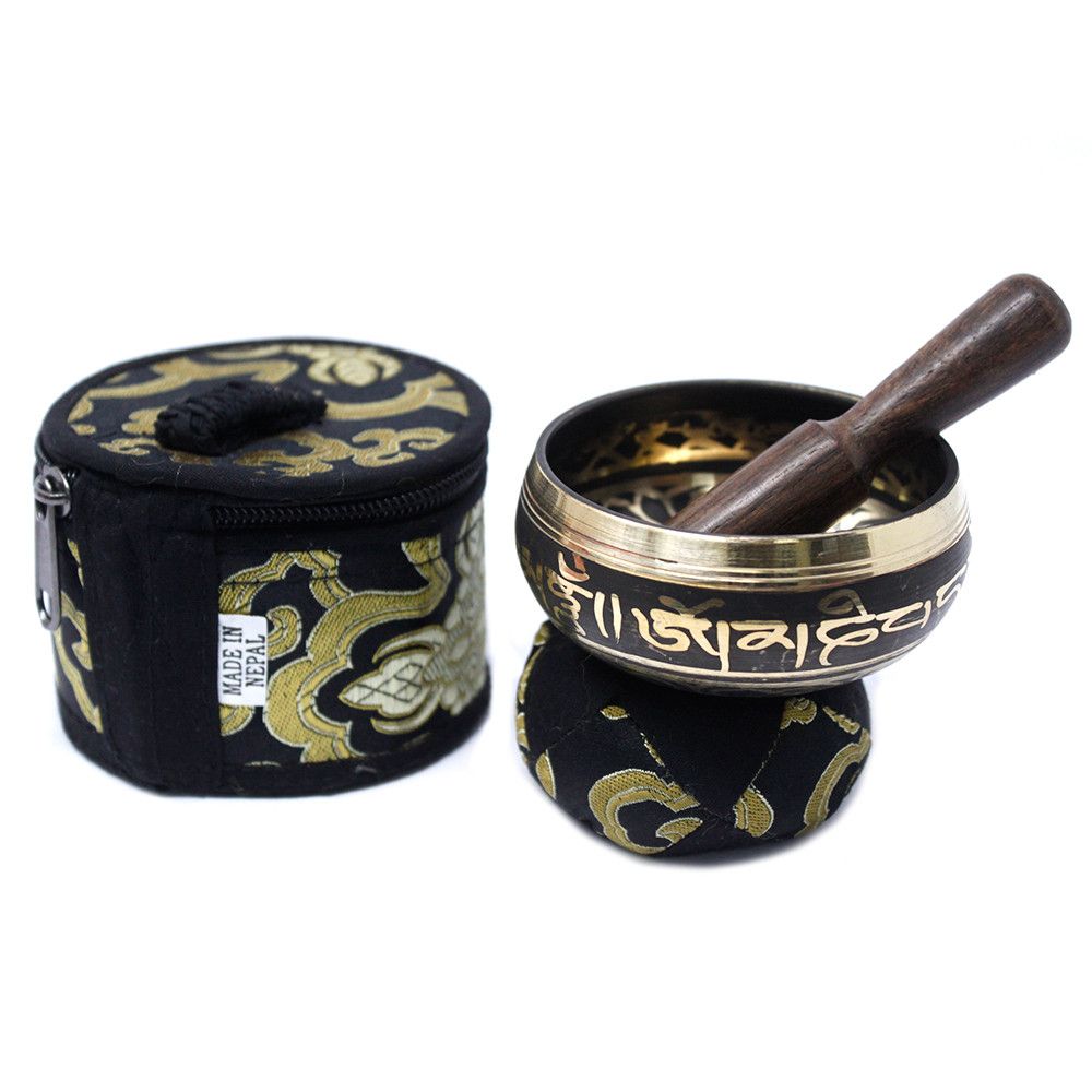 Mini singing bowl on its patterned cushion beside the closed matching case on a white background
