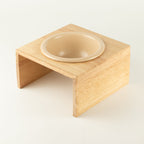 PAW cream bowl seated in the wooden stand, shown at an angle