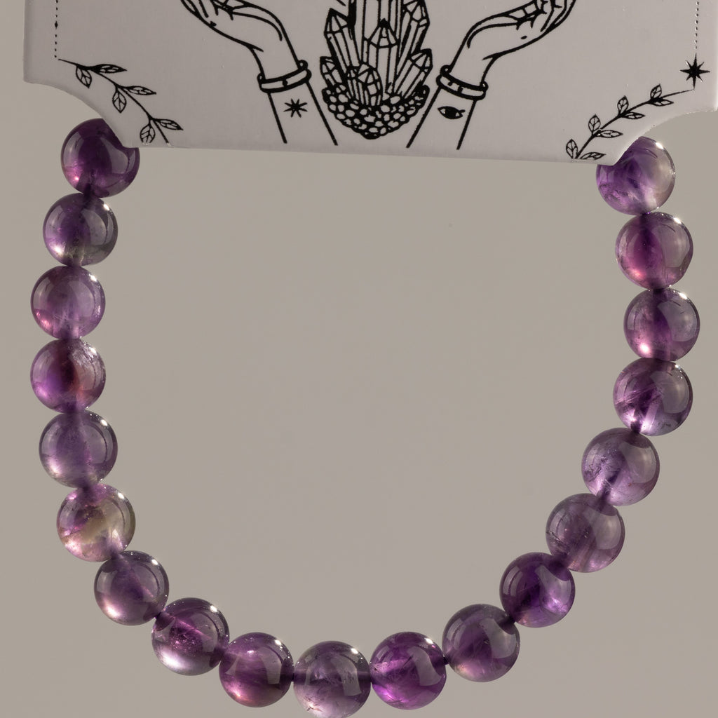 Amethyst bracelet arranged in a loop beneath its presentation card
