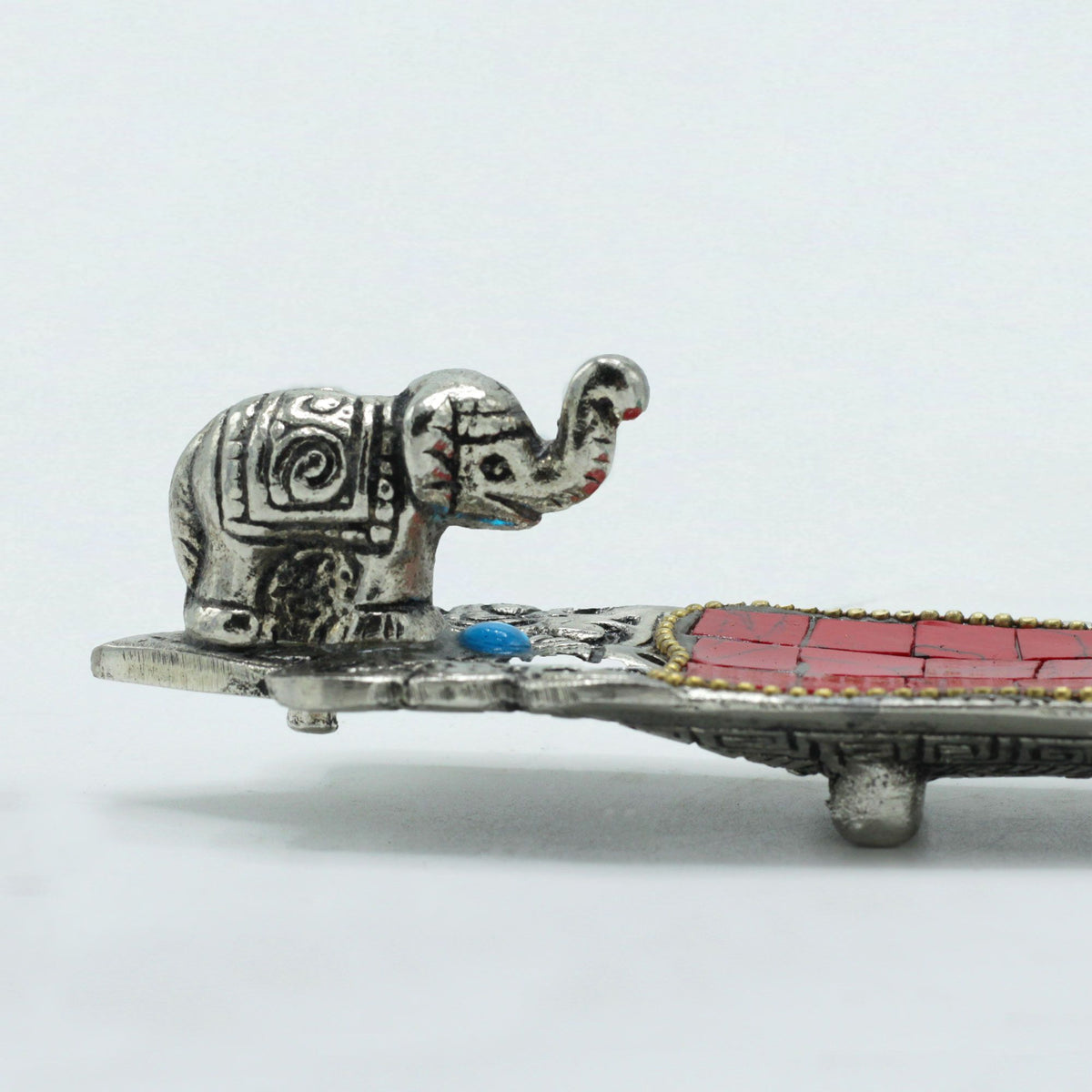 Elephant Long Tibetan Incense Holder, close view of the silver elephant and red inlay on a white background
