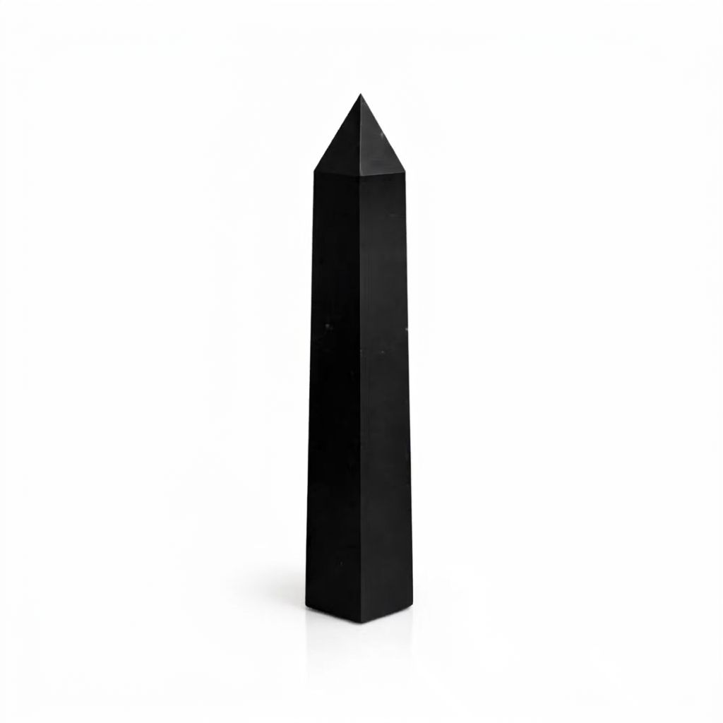 Single black tourmaline obelisk standing upright against a plain white background