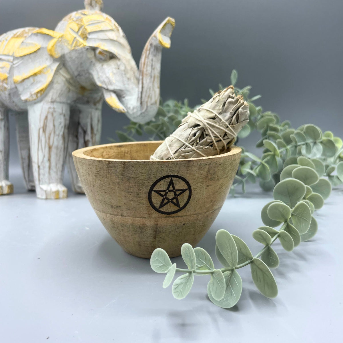 Wooden Smudge and Ritual Offerings Bowl, Pentagram, with a wrapped bundle inside among greenery