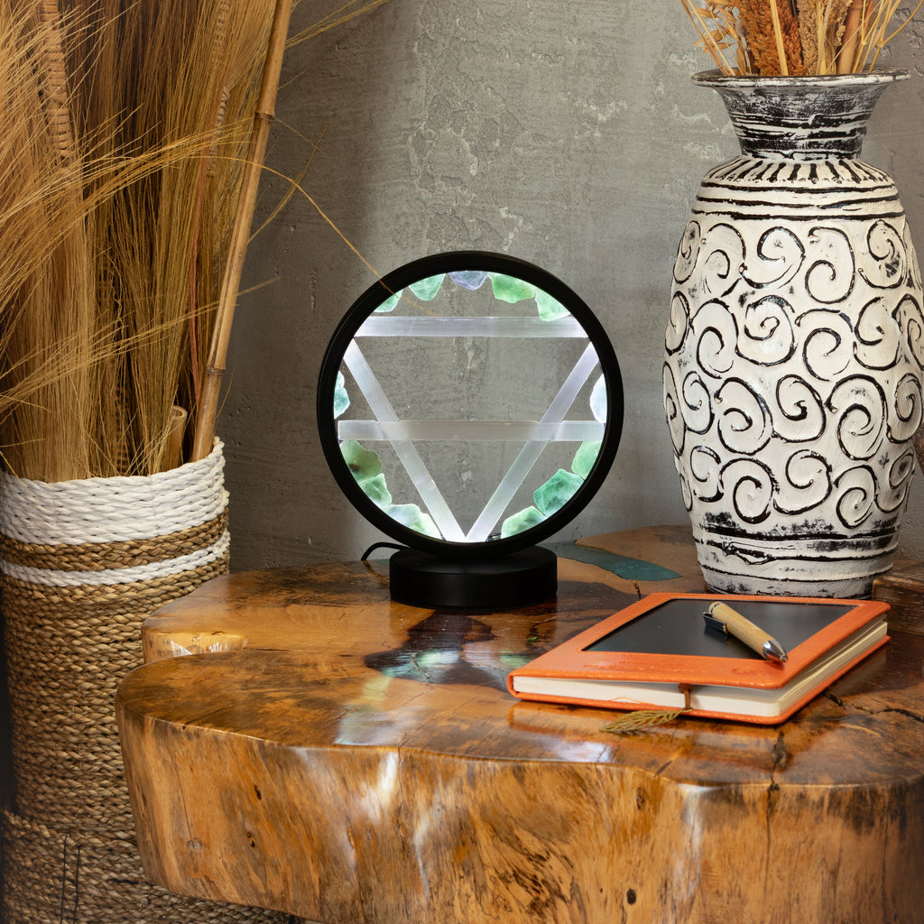Earth halo lamp displayed on a table beside a vase and notebook