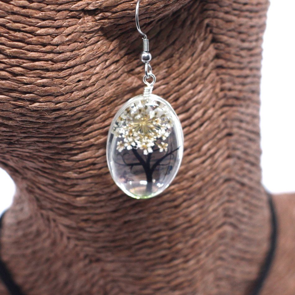 Pressed Flowers, Tree of Life set, White, close-up of a clear oval earring on a brown display bust