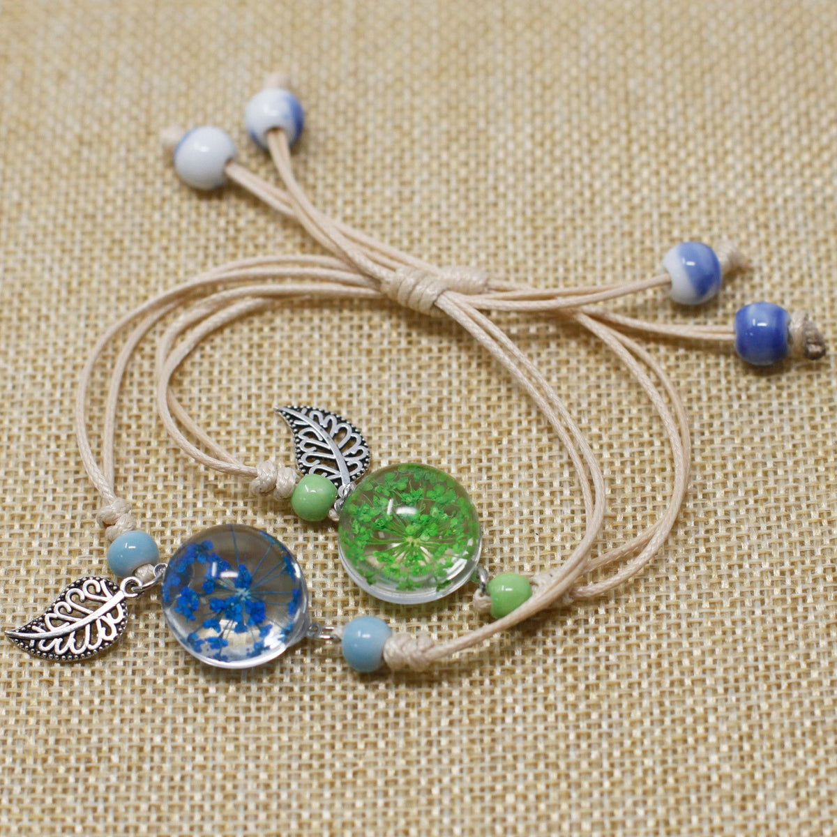 Pressed Flowers, Pretty Flower & Leaf Bracelet with blue and green flower pendants, leaf charms and beads, laid flat