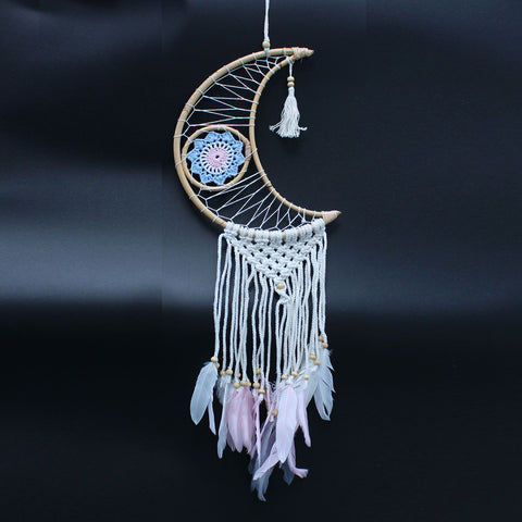 Macrame moon dream catcher with pale feathers and woven web