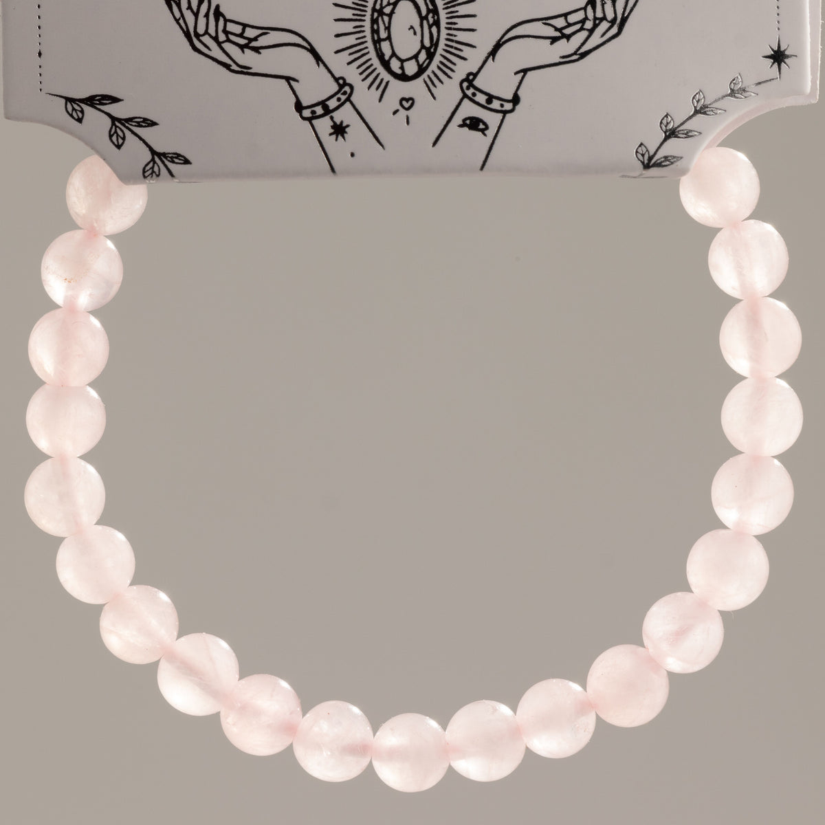 Close view of the rose quartz bracelet hanging in a loop