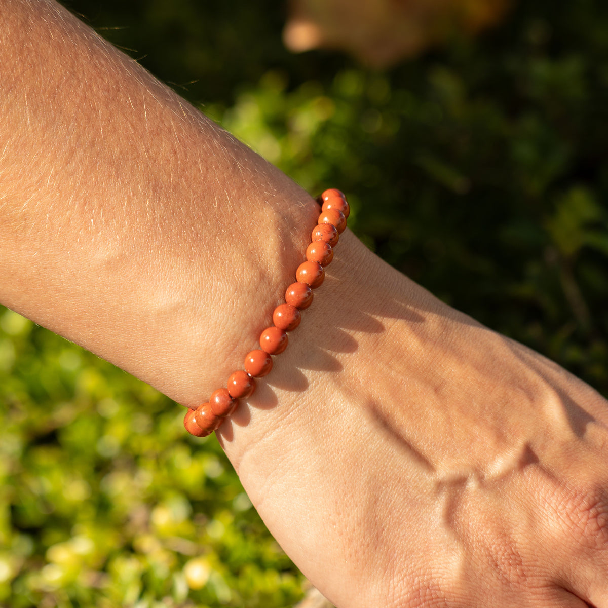 Carnelian bracelet worn on a wrist in sunlight